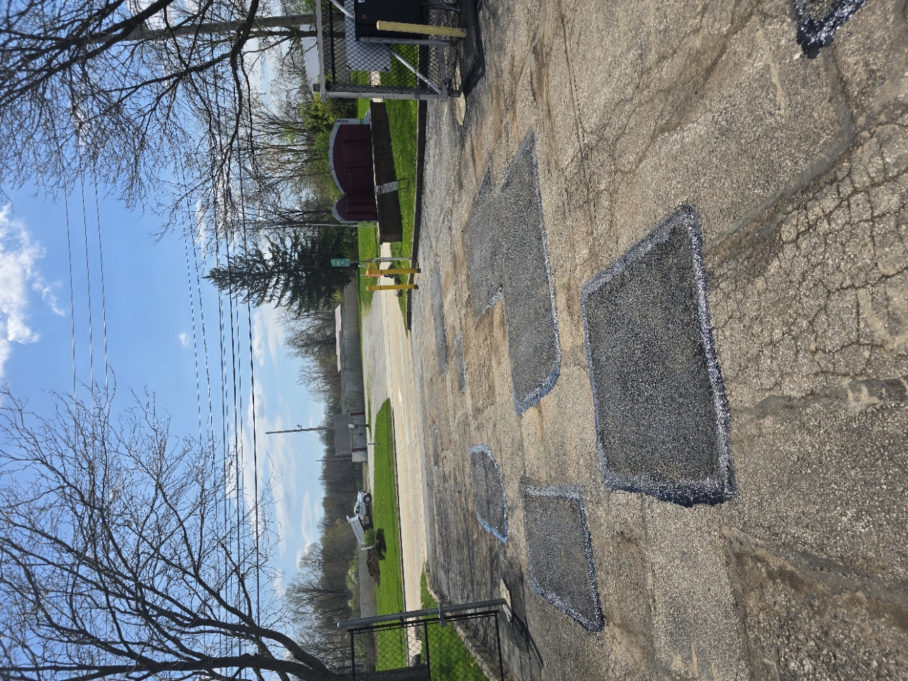 Concrete patch repairs across a cracked drive