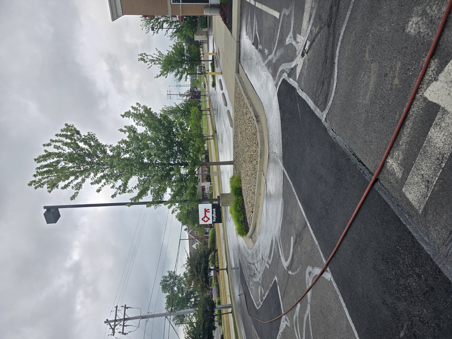 Targeted asphalt patch repairs at a gated commercial entrance