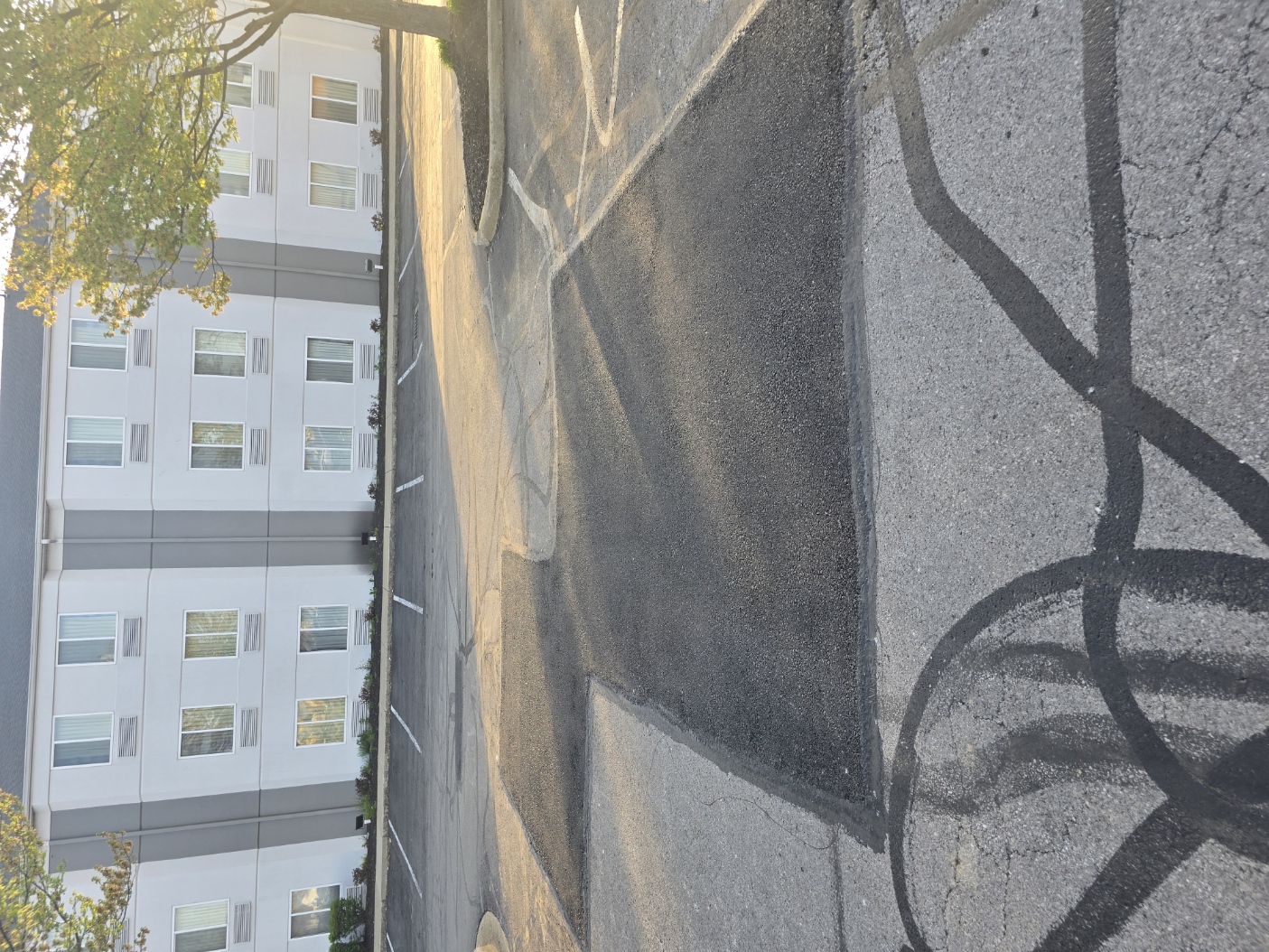 Multiple square-cut asphalt patches on a worn drive