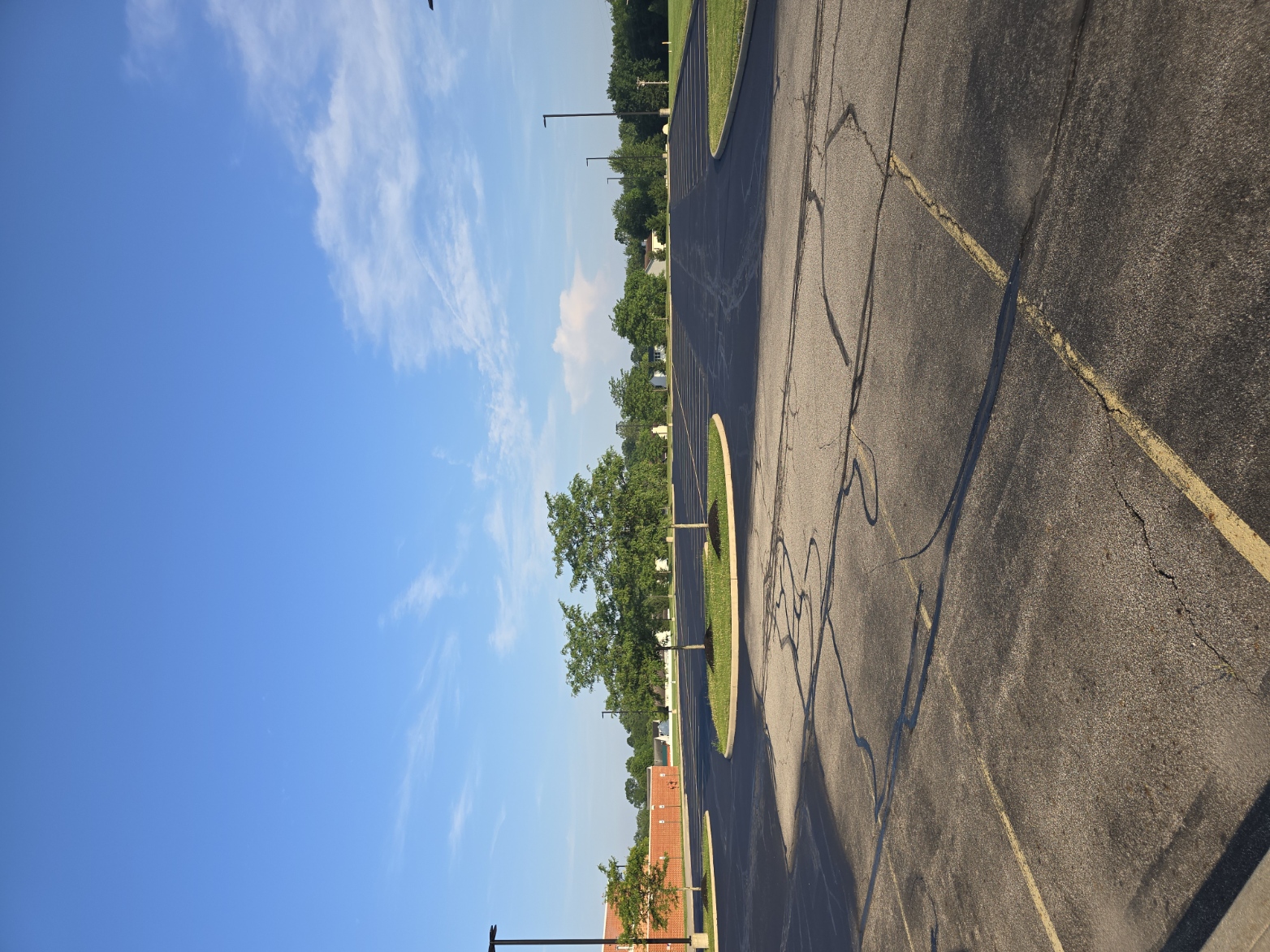 Sealcoating application underway with ribbon cracks visible